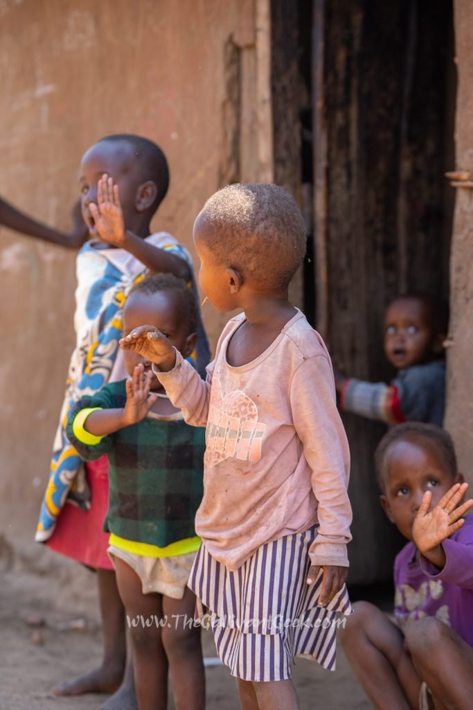 Children standing at the doorway of a house in a Maasai village