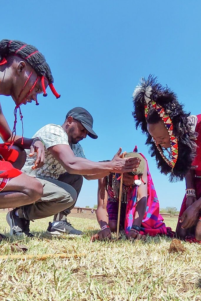 Trying to make fire with two sticks with Maasai men in a village in Kenya