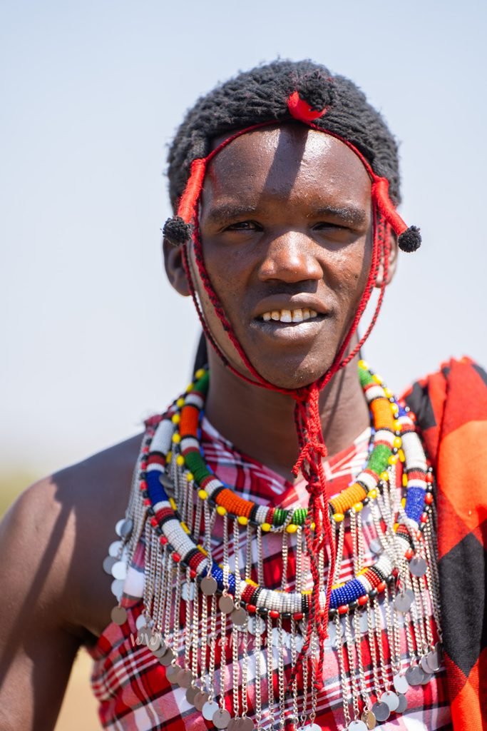 Young Maasai man wearing colourful beaded jewellery and a red headband