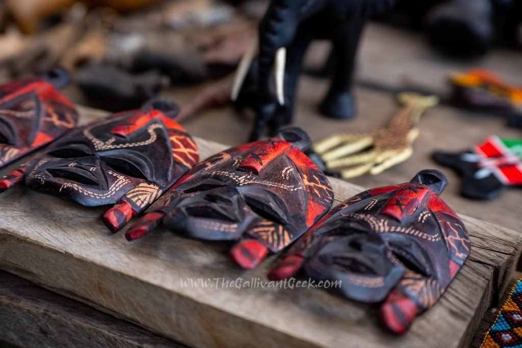 Handmade souvenirs on a wooden table at a Maasai village market