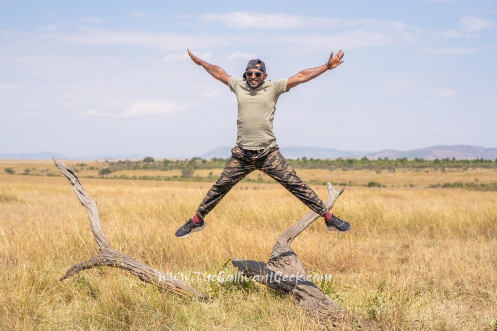 Jumping for joy in a T-shirt and light trousers on a warm afternoon in the Masai Mara